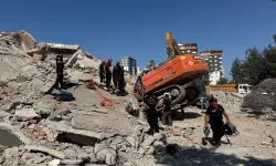 Ağır hasarlı bina yıkılırken iş makinesinin üzerine devrildi